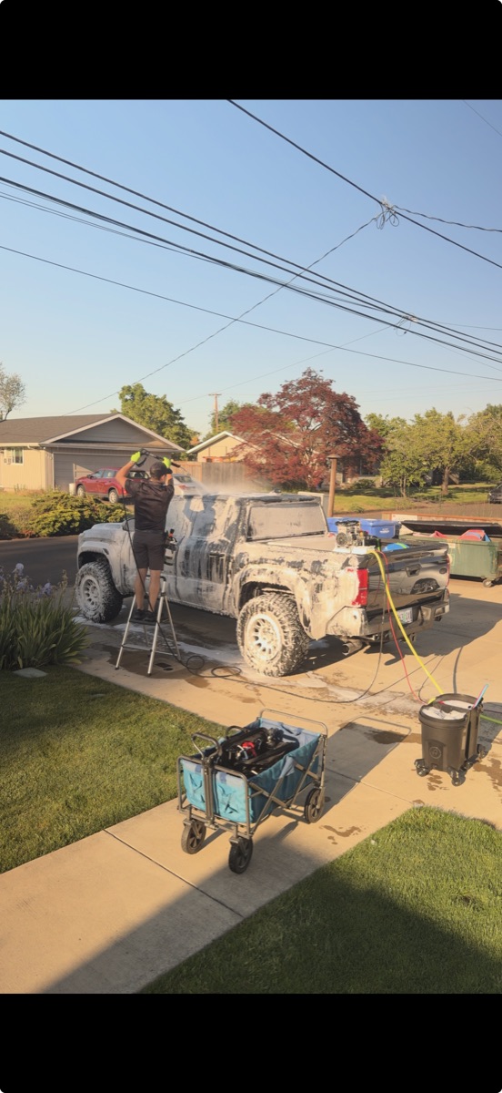 Pickup truck covered in cleaning foam at golden-hour