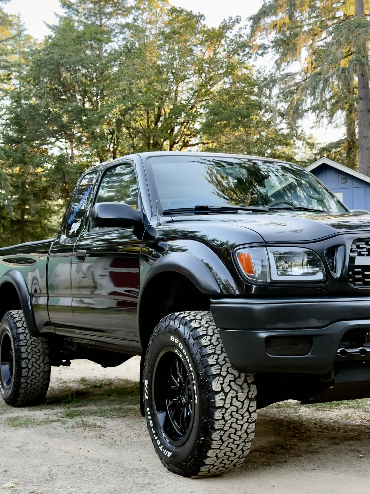 Lifted black Toyota Tacoma freshly detailed, paint glowing at golden hour
