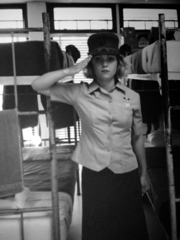 Chuck's mother saluting in Marine Corps dress uniform in the barracks